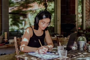 uma mulher sentada em uma mesa trabalhando em um laptop