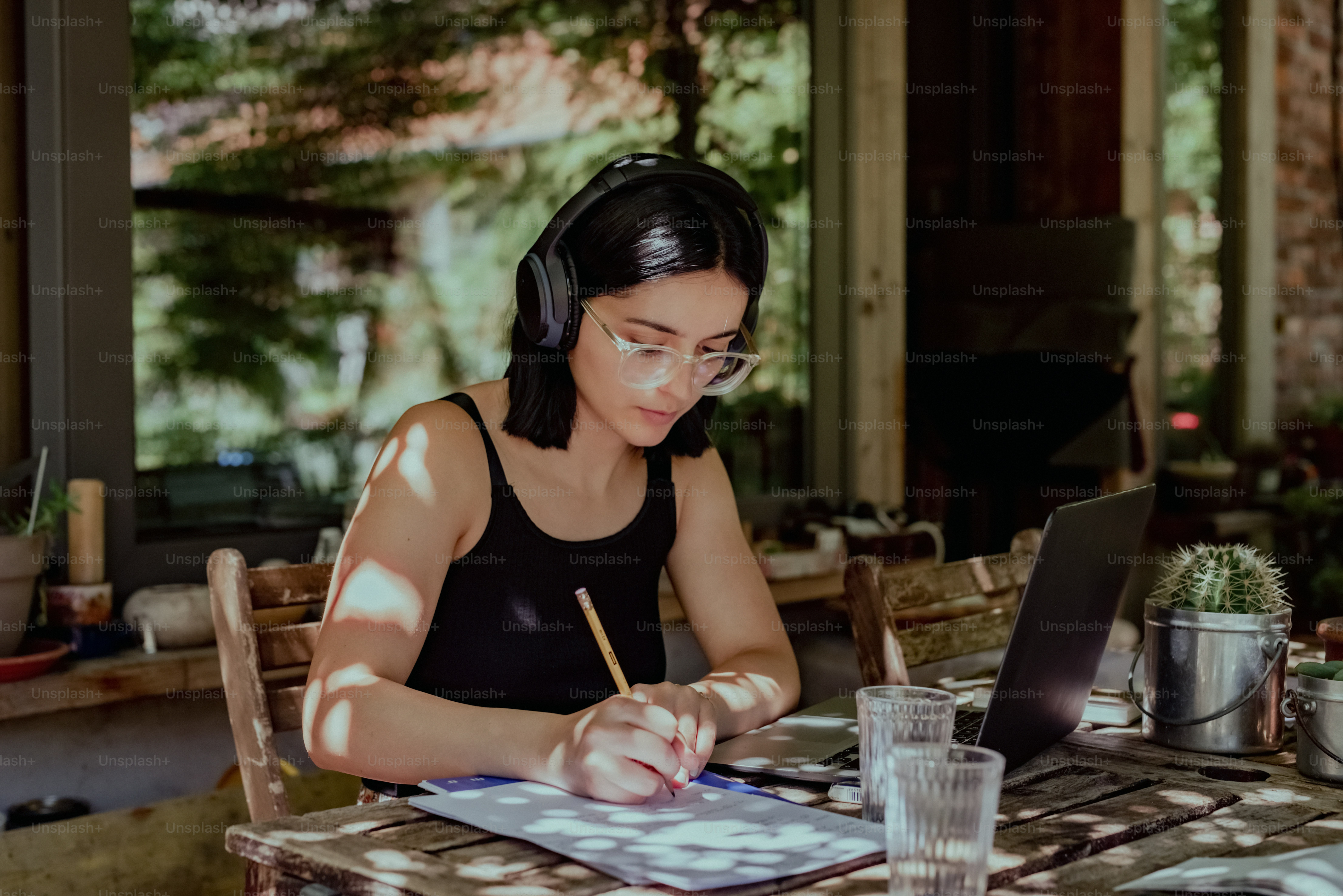 a woman sitting at a table working on a laptop