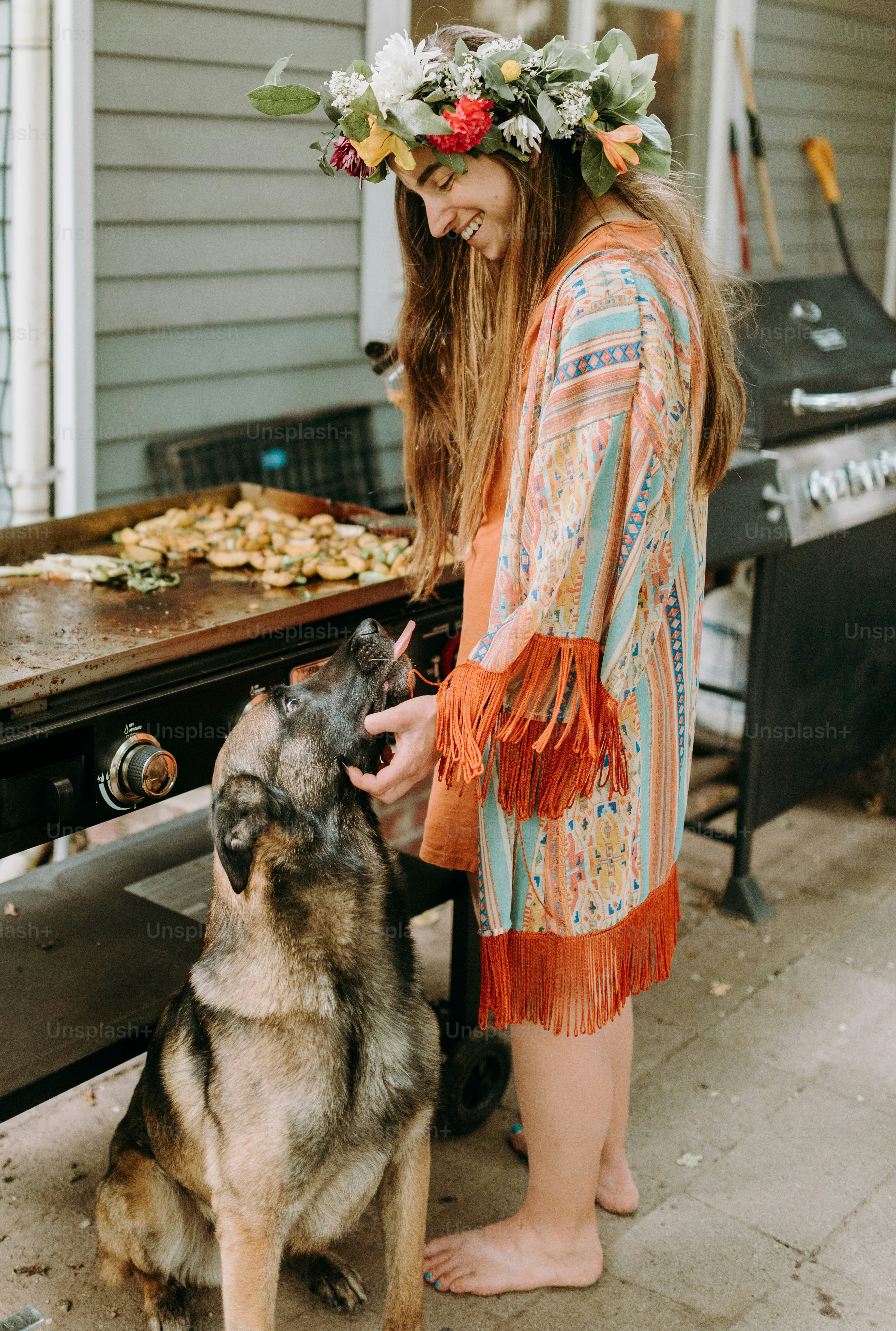 a woman standing next to a dog with a flower crown on her head