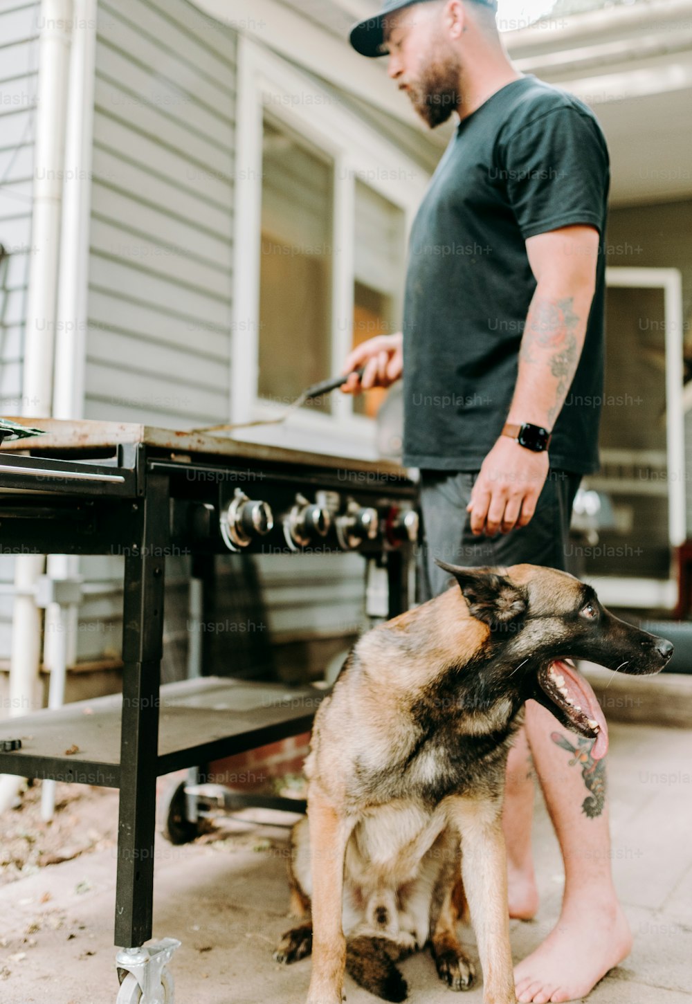 Ein Mann, der neben einem Hund auf einer Terrasse steht