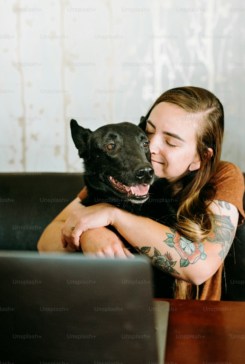 Eine Frau, die mit ihrem Hund auf einer Couch sitzt