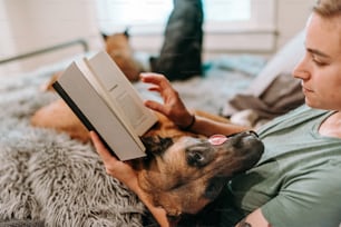 a man reading a book to his dog