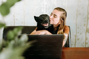 a woman sitting in a chair holding a dog