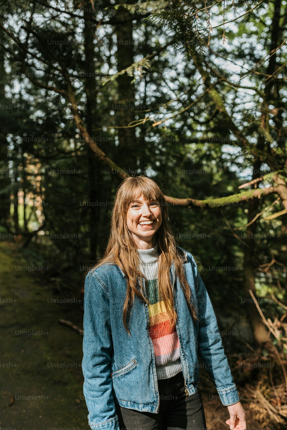 a woman standing in front of some trees