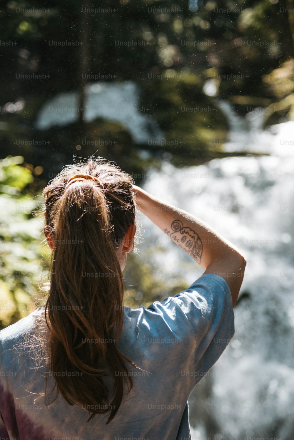 a woman standing in front of a waterfall