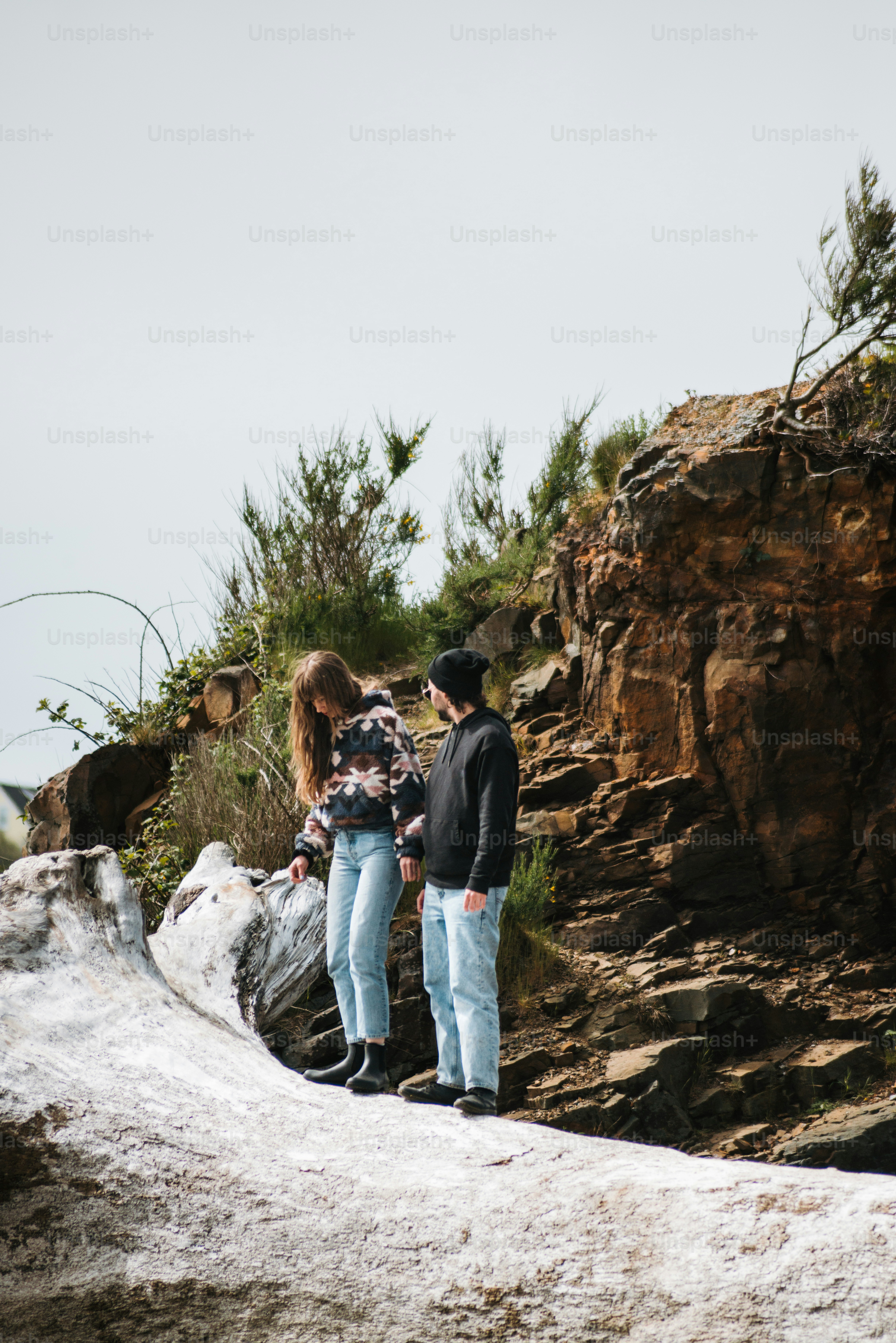 a man and a woman standing on top of a mountain