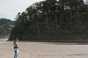 Una donna in piedi sulla cima di una spiaggia sabbiosa