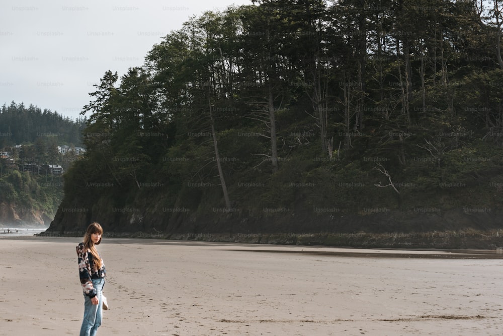 a woman standing on top of a sandy beach