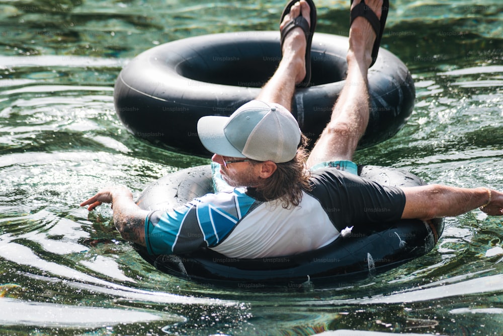 a man laying on an inner tube in the water