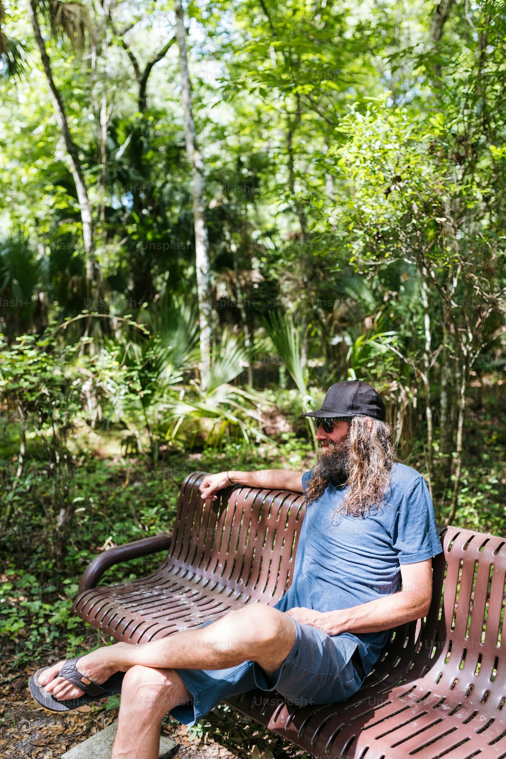 a man sitting on a bench in the woods