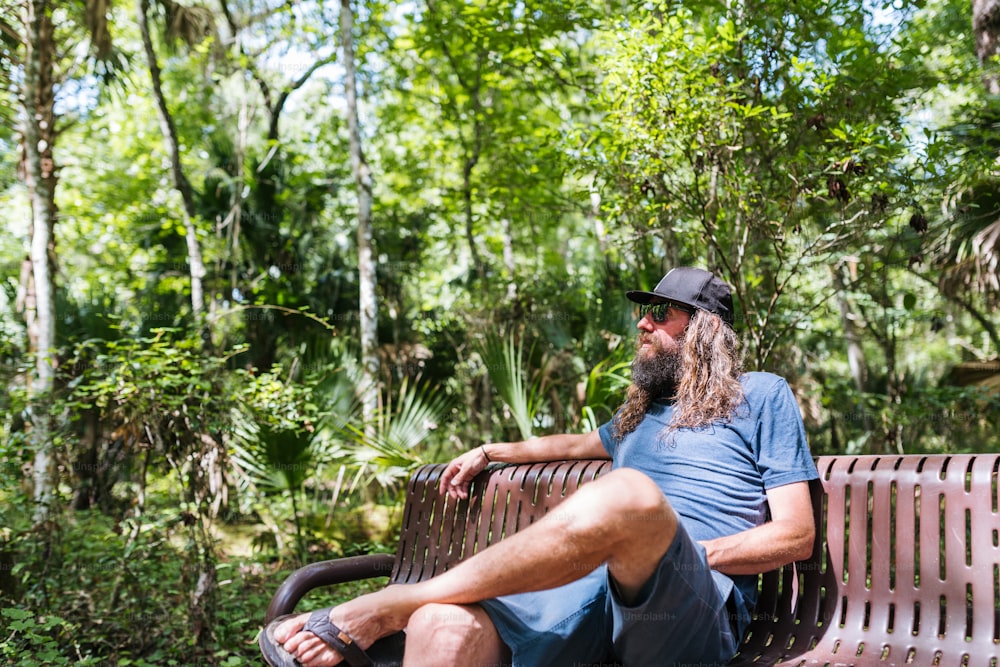 Un homme avec une longue barbe assis sur un banc