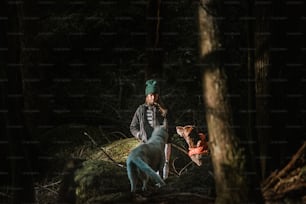 a man standing next to a dog in the woods