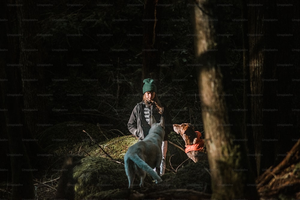 Un hombre parado junto a un perro en el bosque