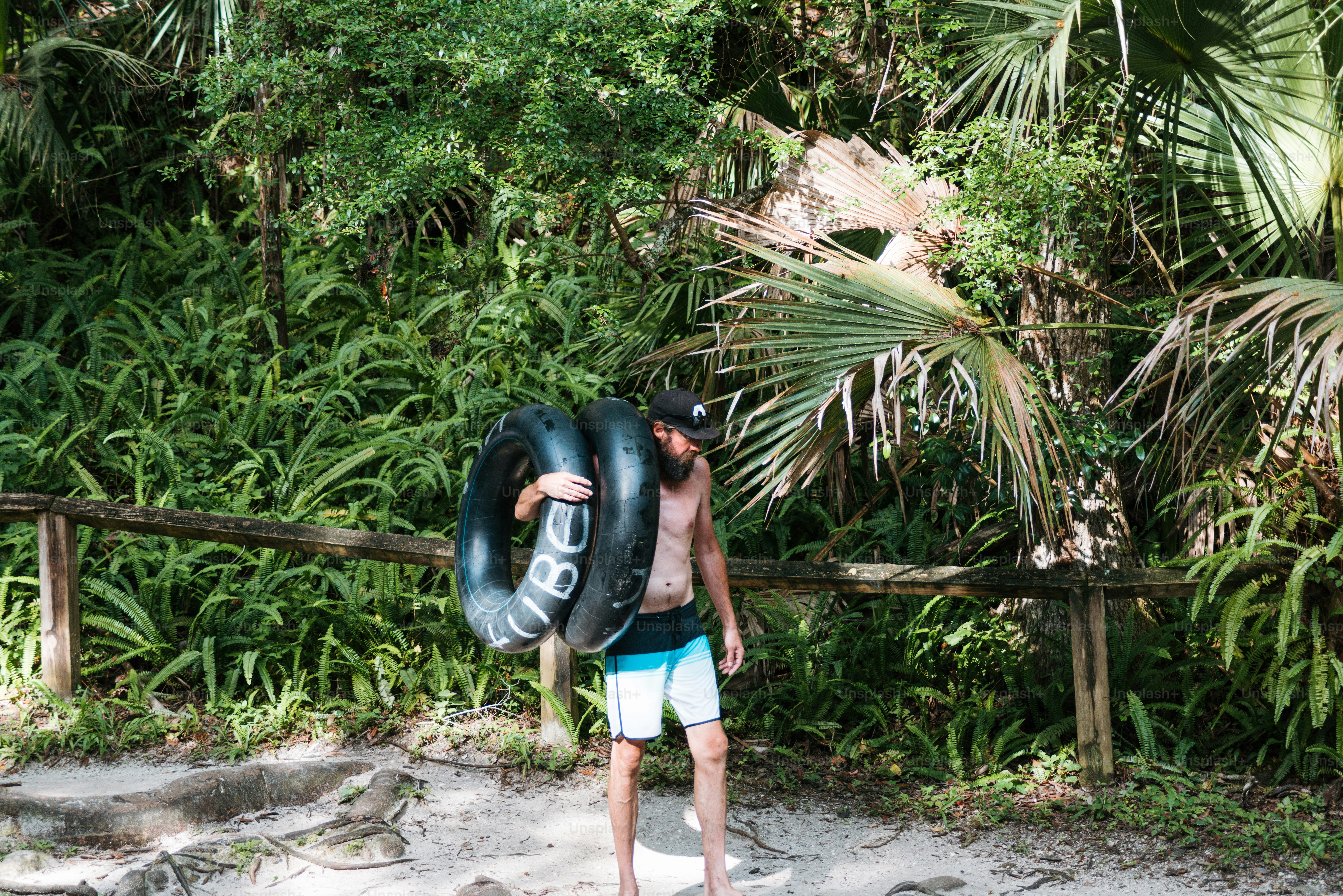 a man carrying an inflatable tube on a beach