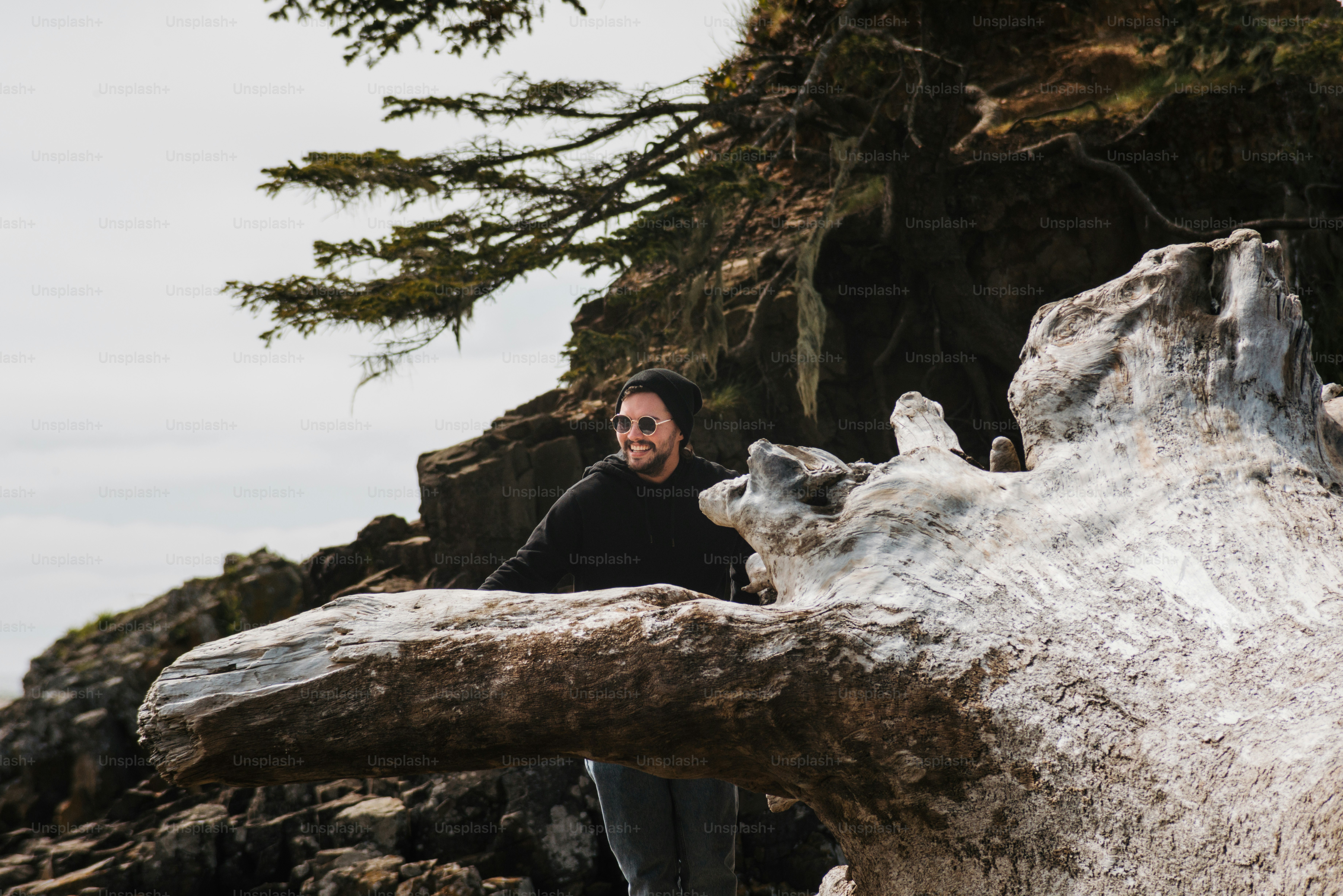 a man standing next to a large piece of wood