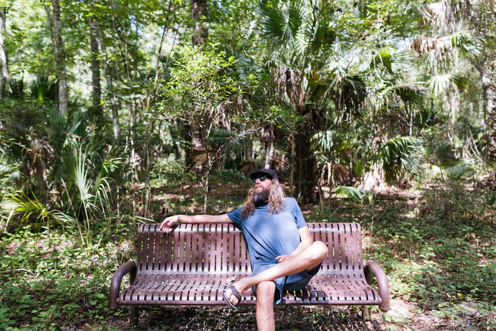 a man sitting on a bench in the woods