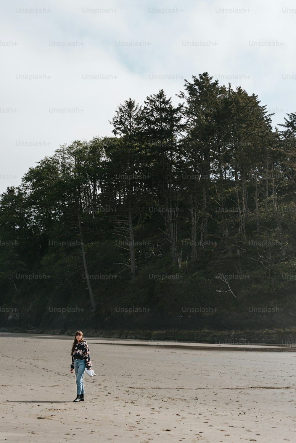 a woman standing on top of a sandy beach