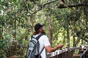 a man with a backpack is standing on a bridge