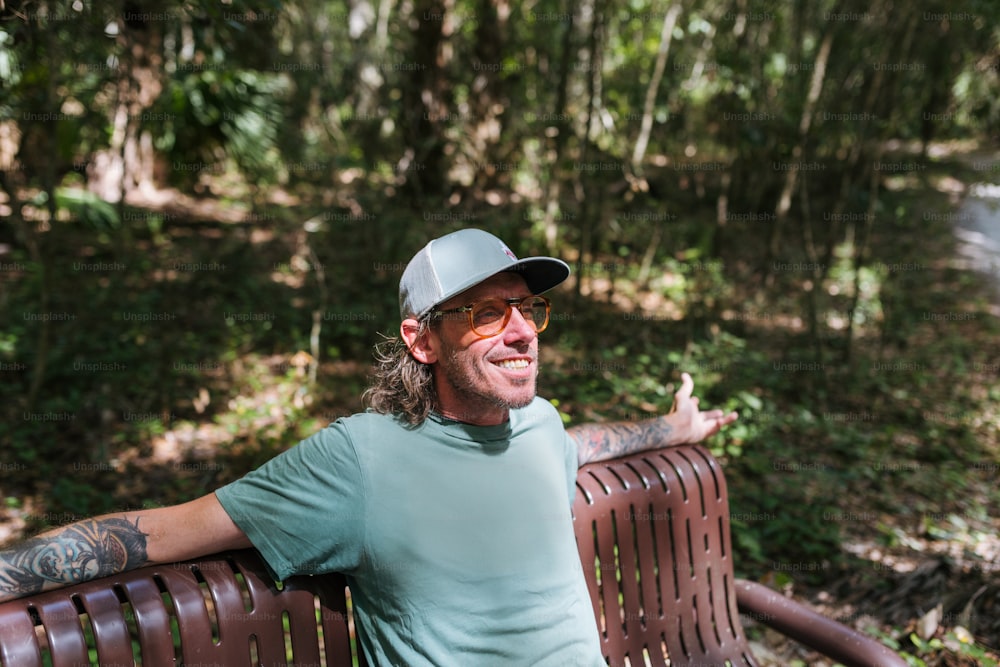 Un uomo seduto su una panchina nel bosco