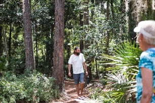 a man is walking through the woods with a suitcase