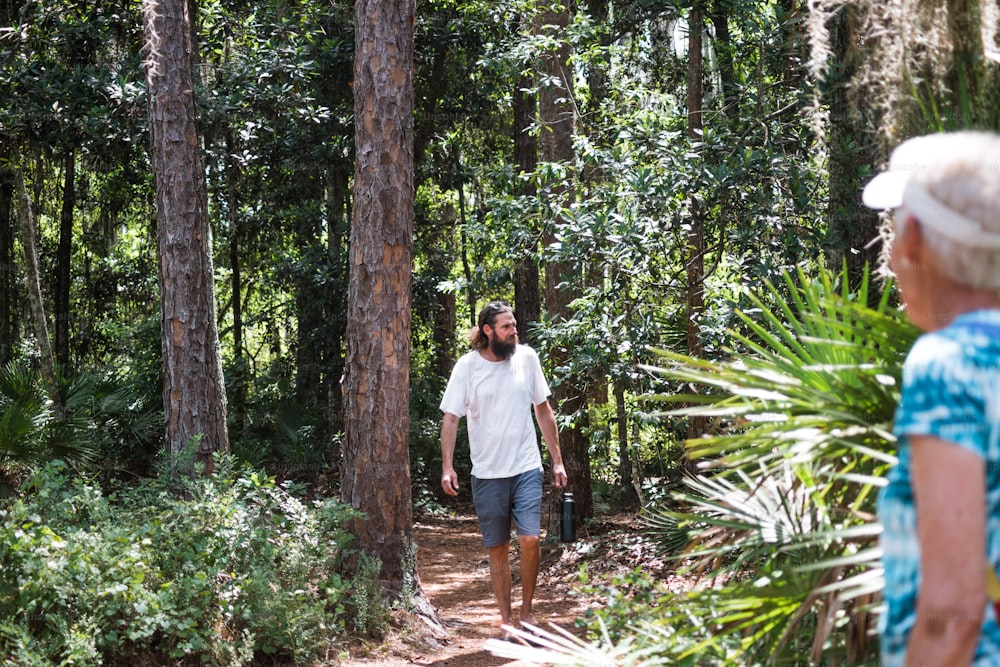 a man is walking through the woods with a suitcase
