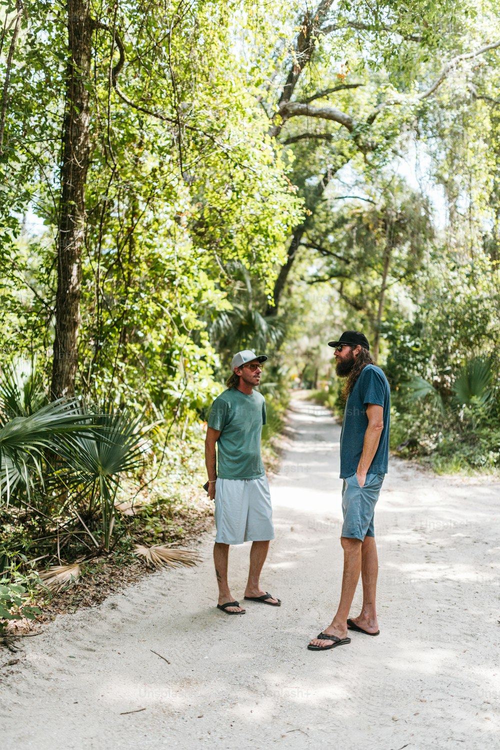 a couple of men standing on top of a dirt road