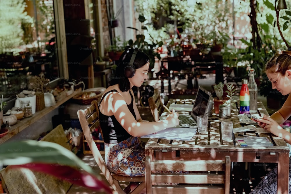 two women sitting at a table with laptops