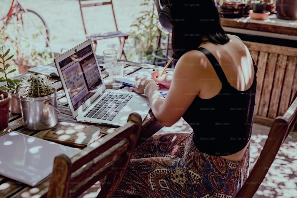 a woman sitting at a table using a laptop computer