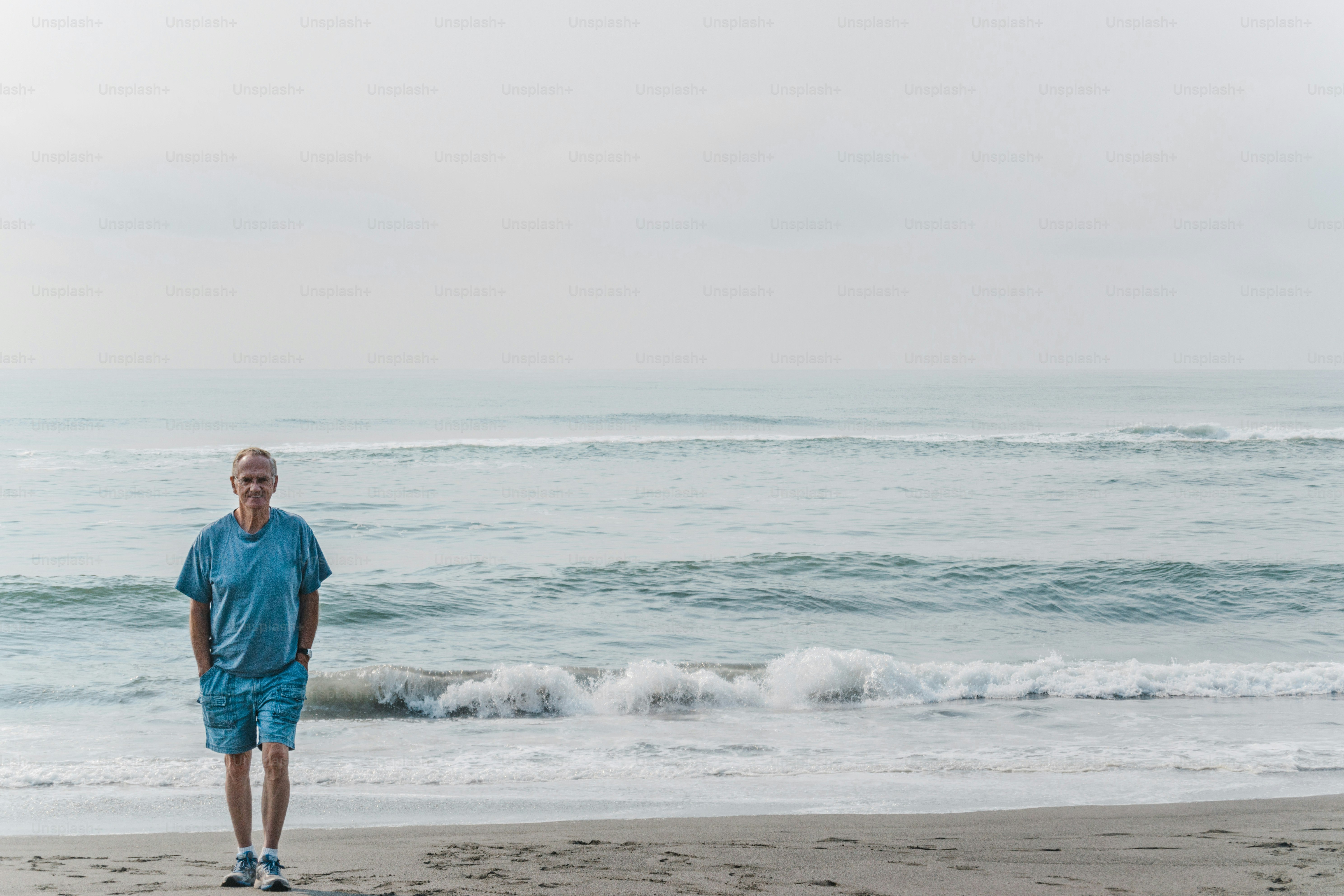 a man standing on a beach next to the ocean