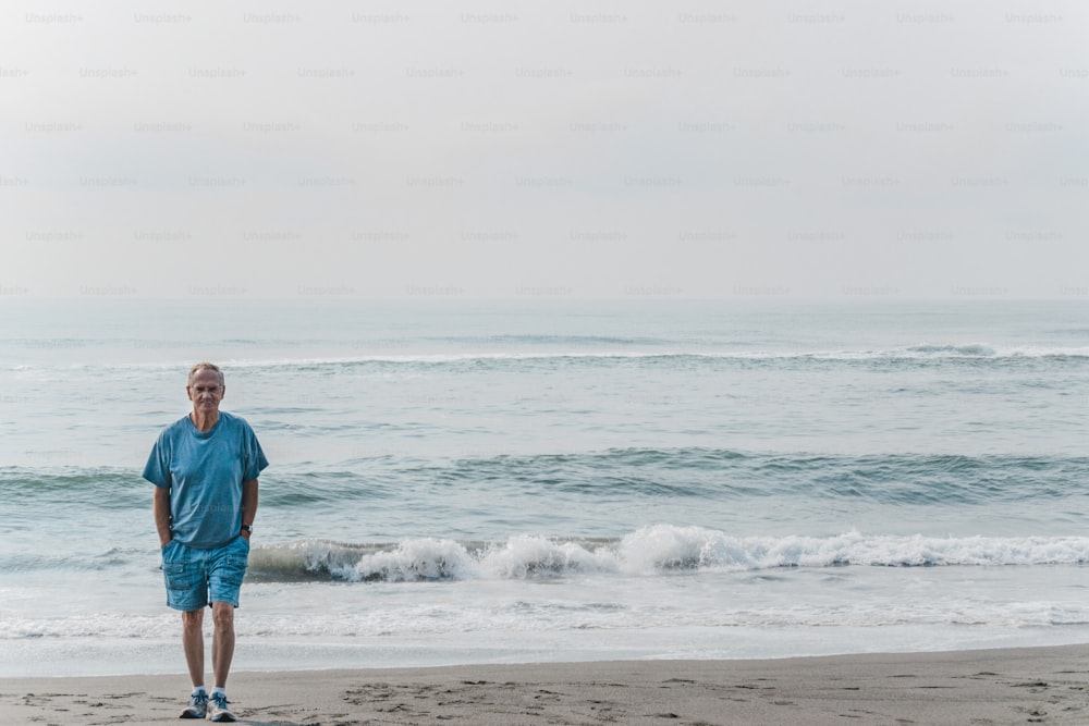 Ein Mann, der an einem Strand neben dem Meer steht