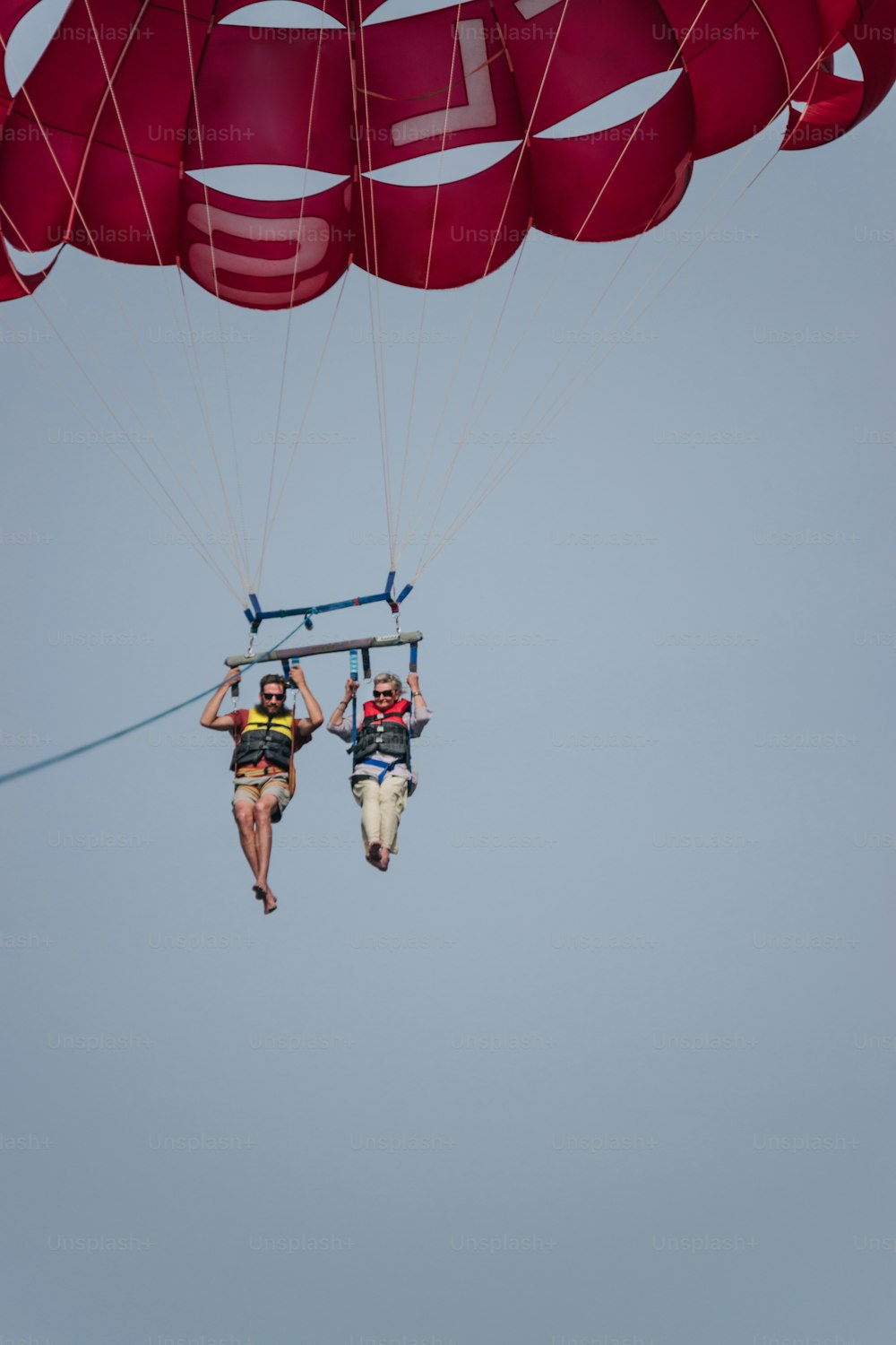 a couple of people riding on top of a parachute