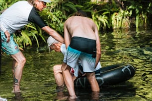 a couple of men standing next to each other in the water