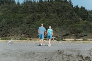 Un hombre y una mujer tomados de la mano mientras están de pie en una playa