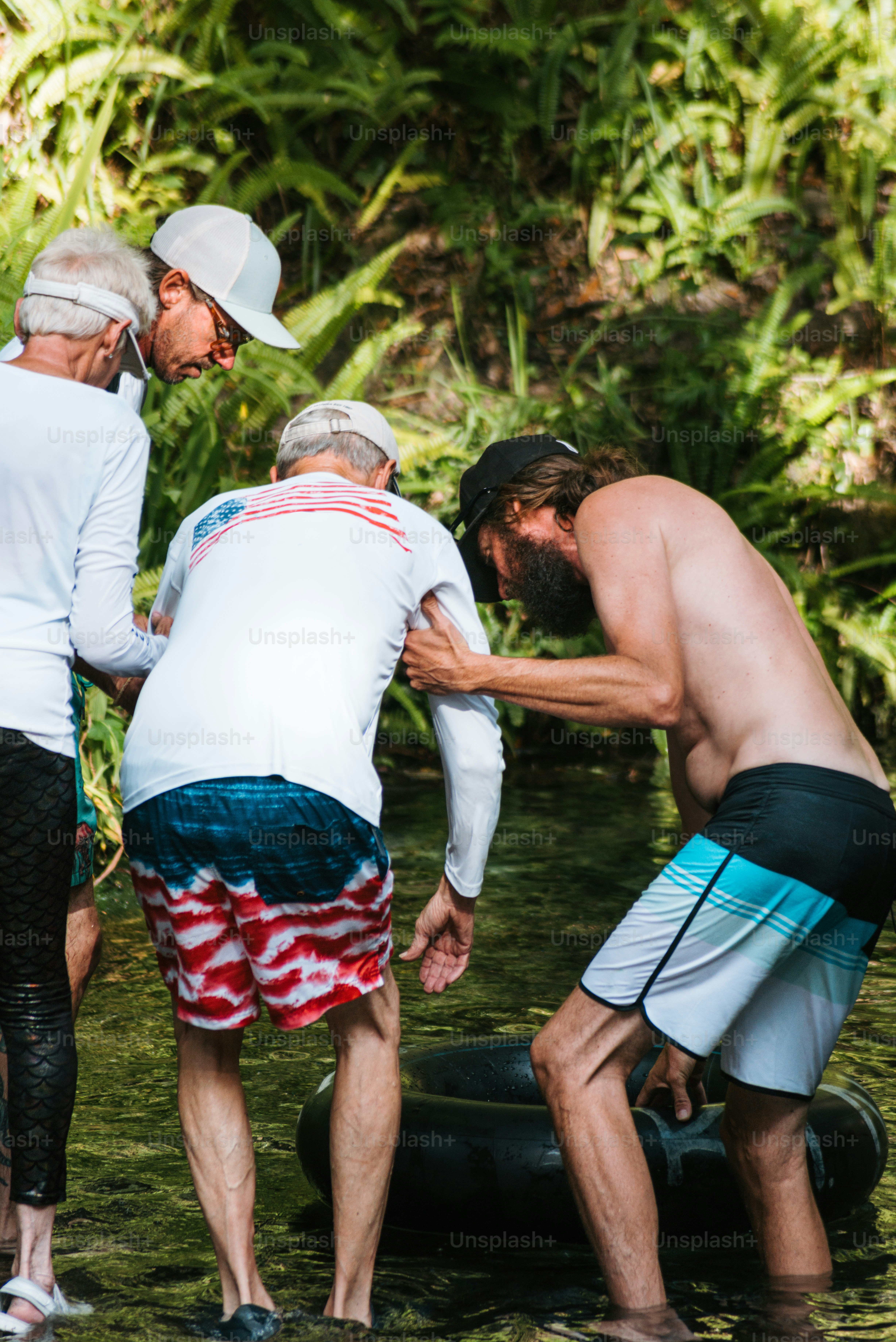 A group of men standing in a river next to each other photo – Outdoorsy ...