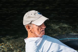 an older man wearing a hat and a white shirt