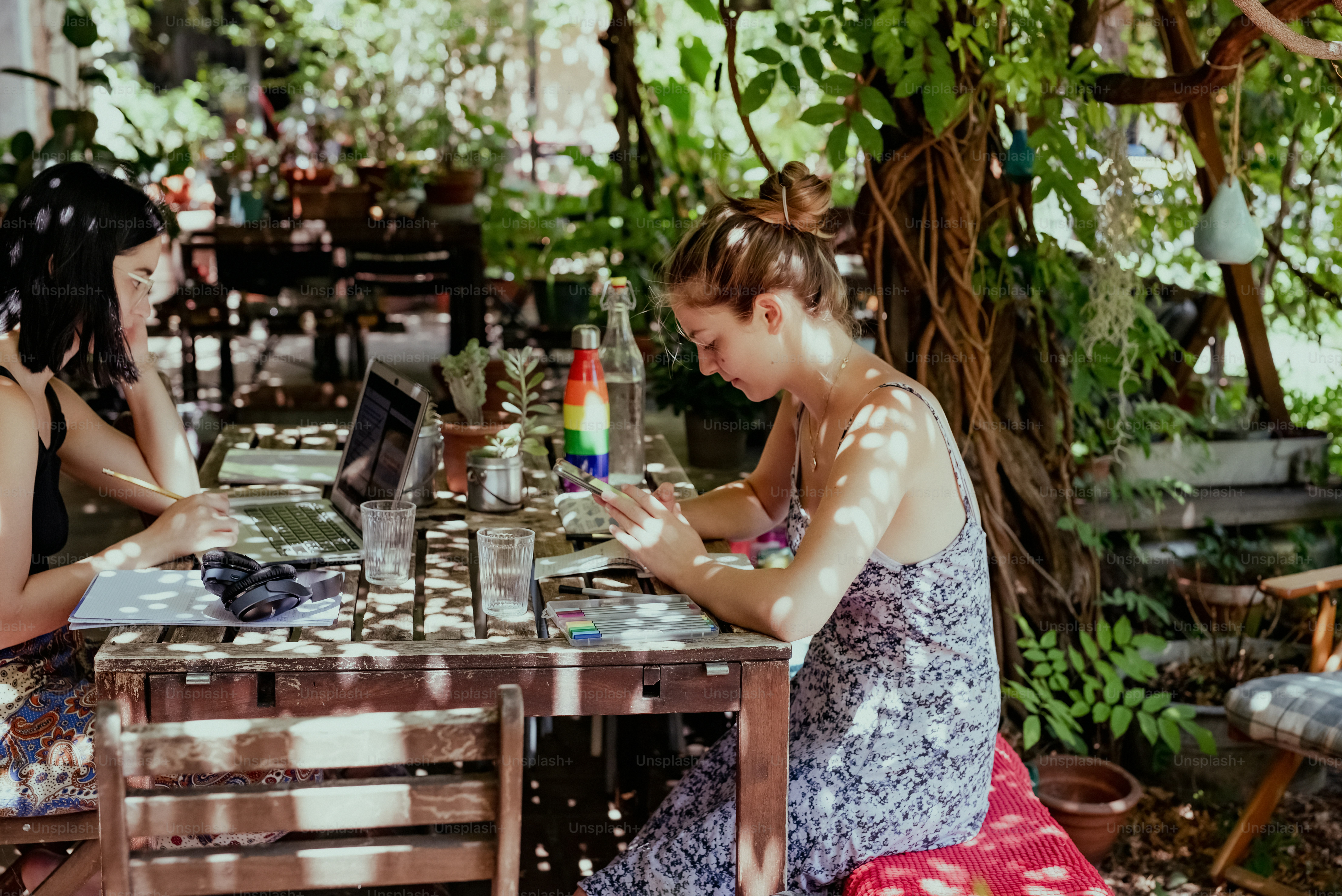 um casal de mulheres sentadas em uma mesa de madeira