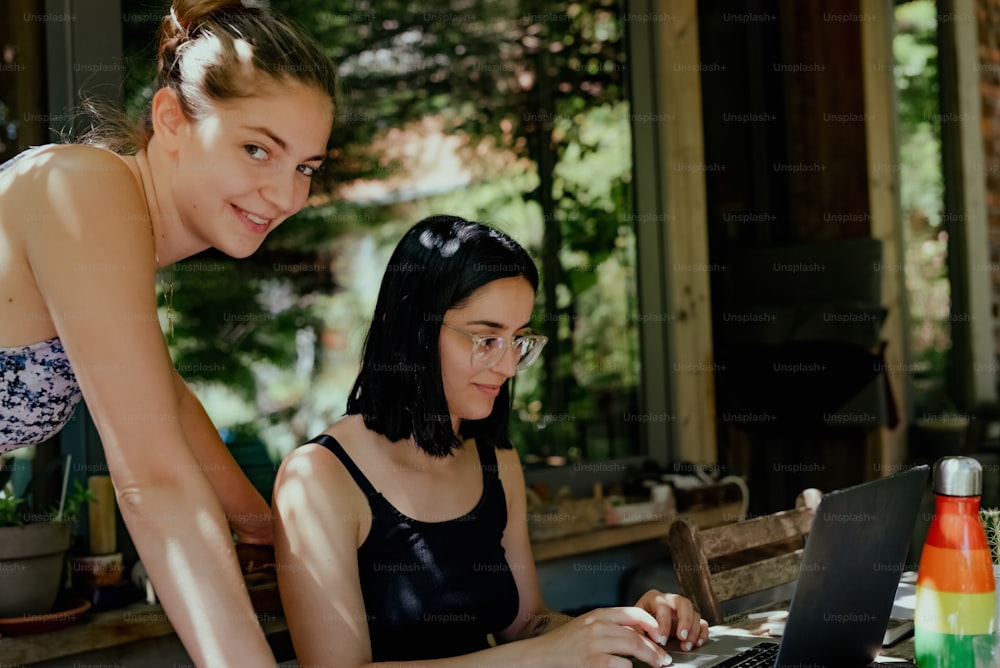 two women are looking at a laptop screen