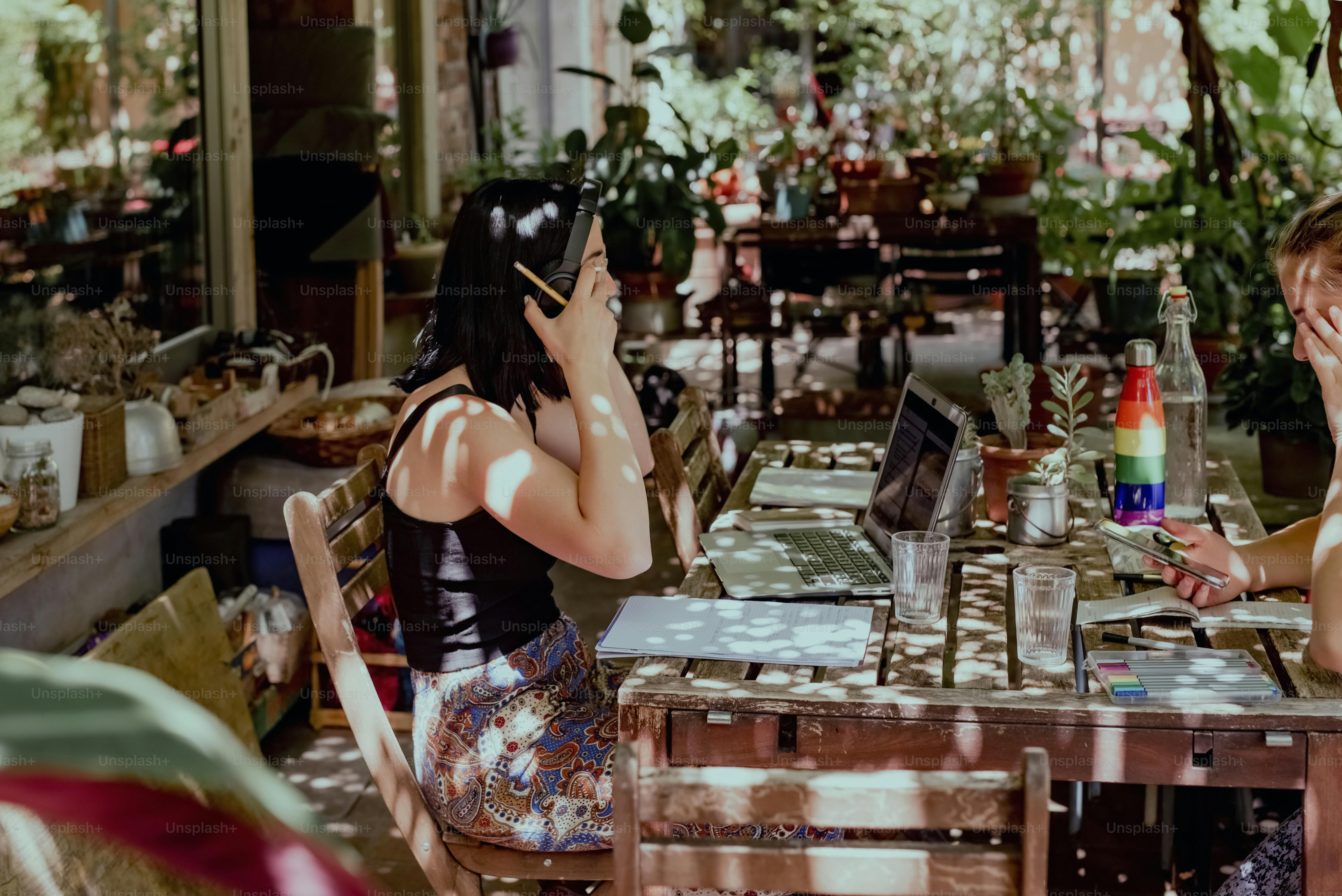 um casal de mulheres sentadas em uma mesa com laptops