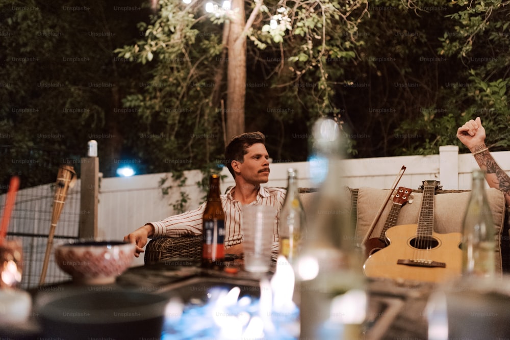 a couple of men sitting at a table with guitars