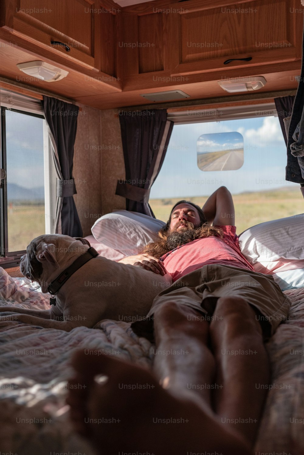 um homem deitado em uma cama com um cachorro