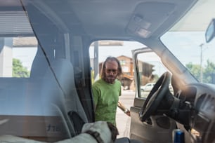 a man standing in the drivers seat of a truck