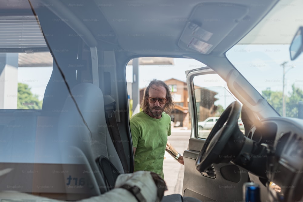 a man standing in the drivers seat of a truck