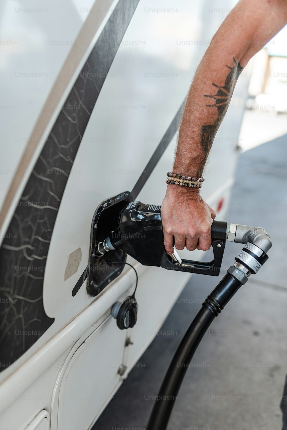 Un uomo che pompa benzina nella sua auto in una stazione di servizio