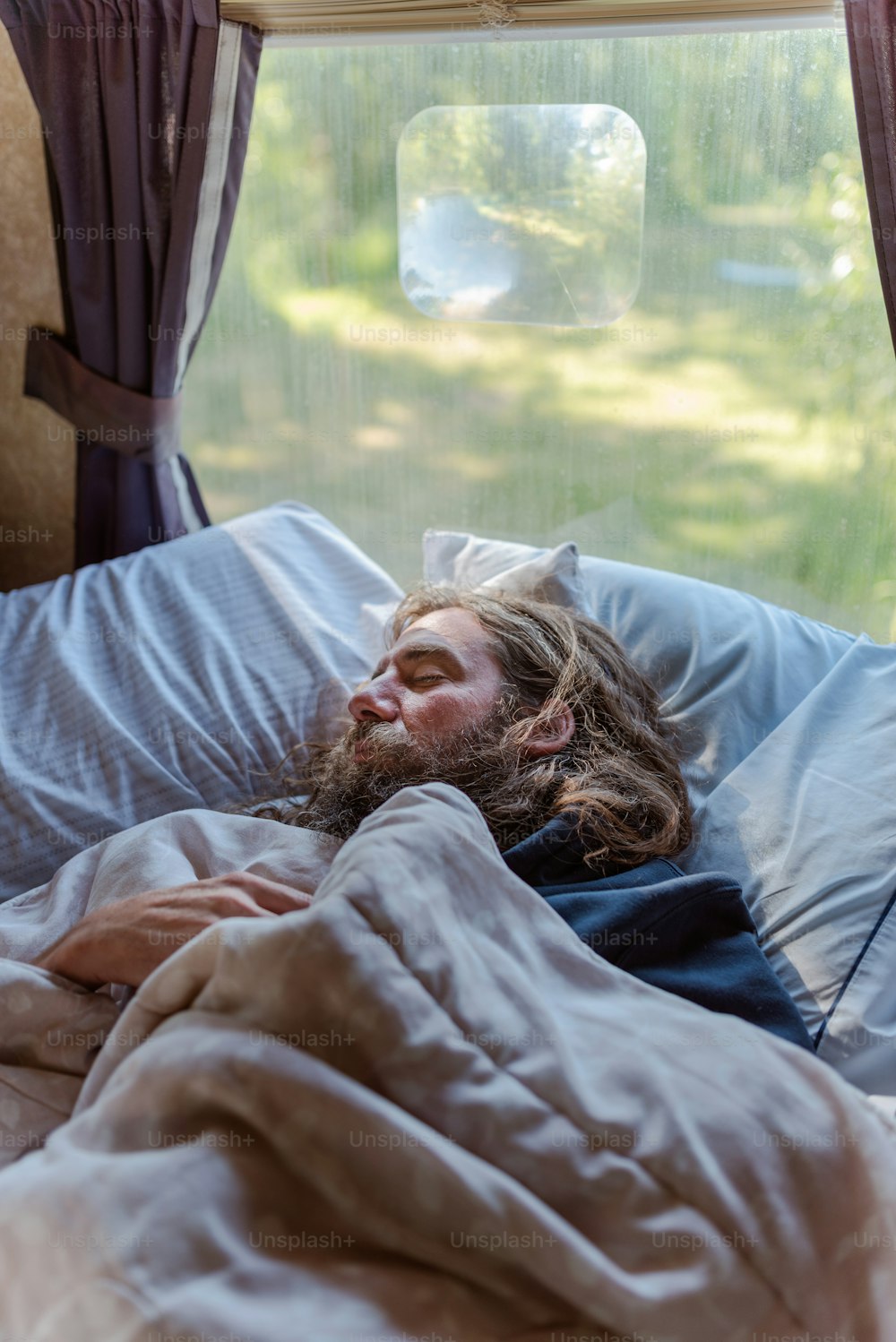Un homme allongé dans son lit sous une couverture