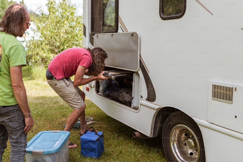 a couple of people standing next to a white trailer