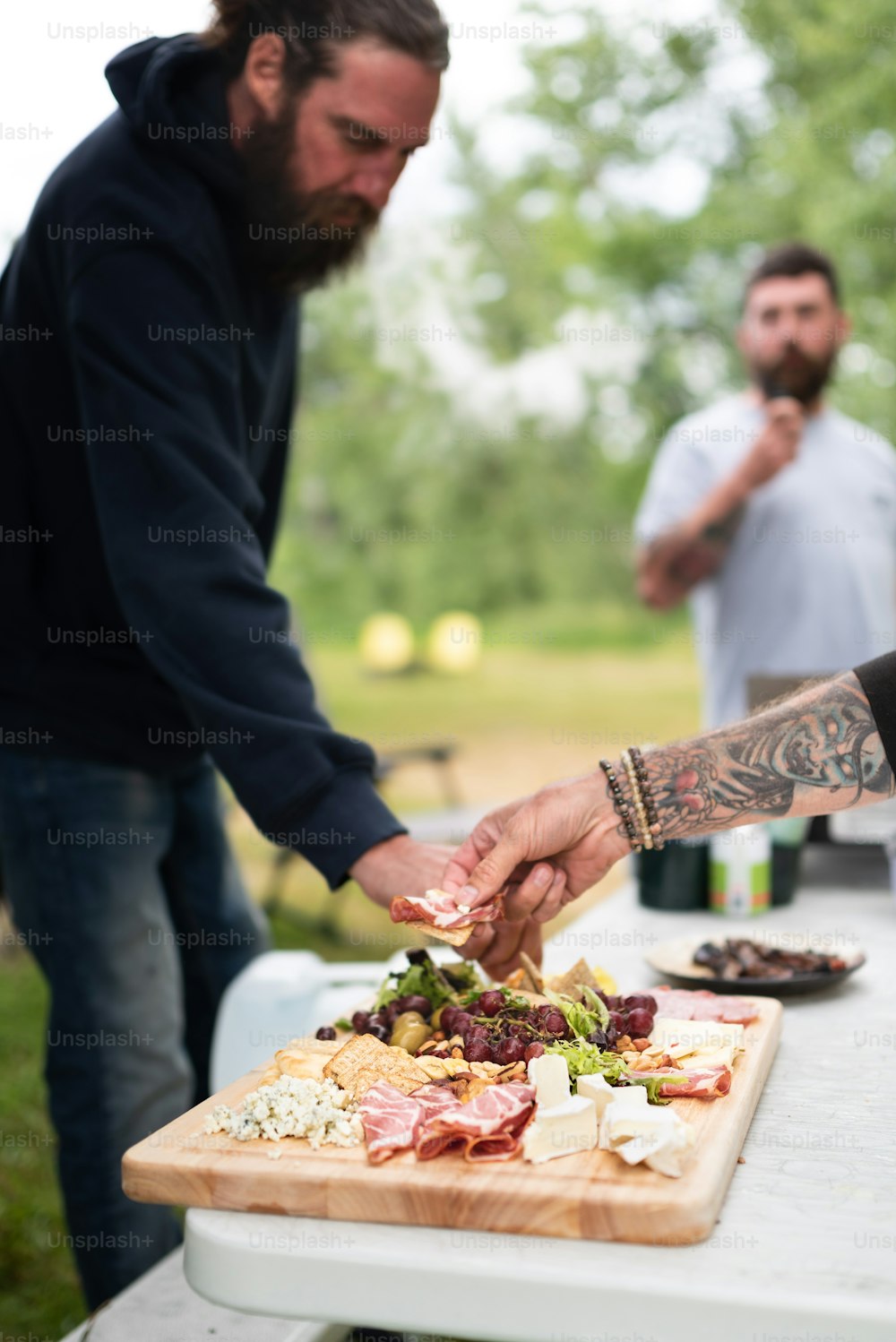 a man cutting up a salad on top of a wooden cutting board