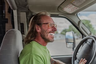 a man in a green shirt driving a truck