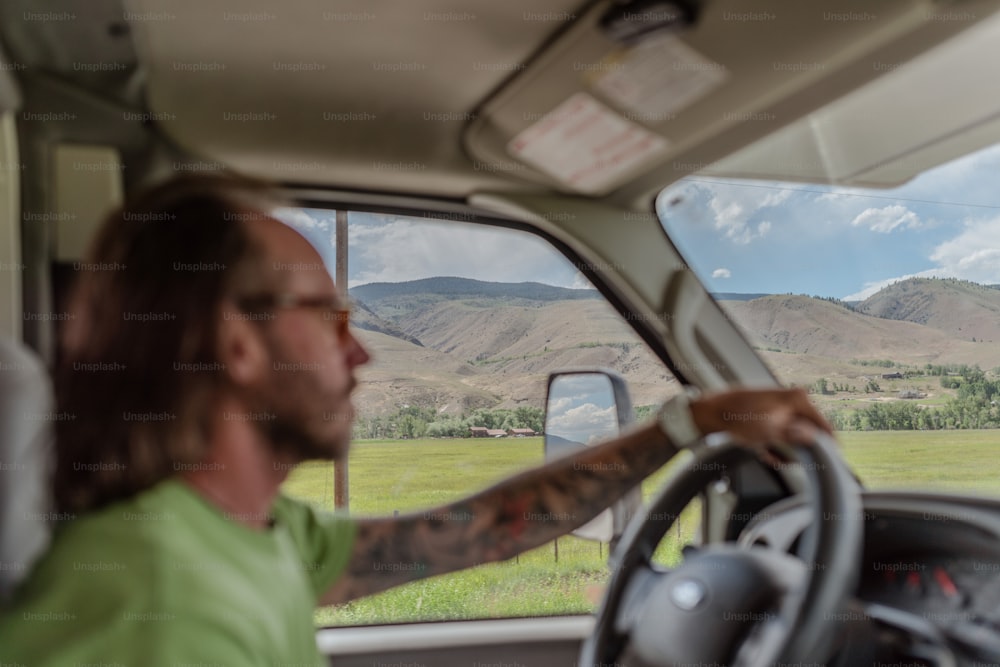 a man driving a truck with mountains in the background