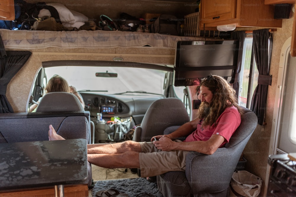 a man sitting in a chair inside of a camper