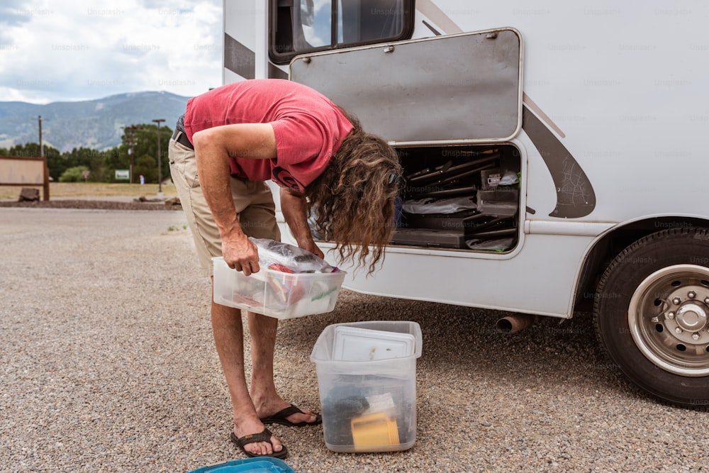 a woman bending over to pick up food from a container